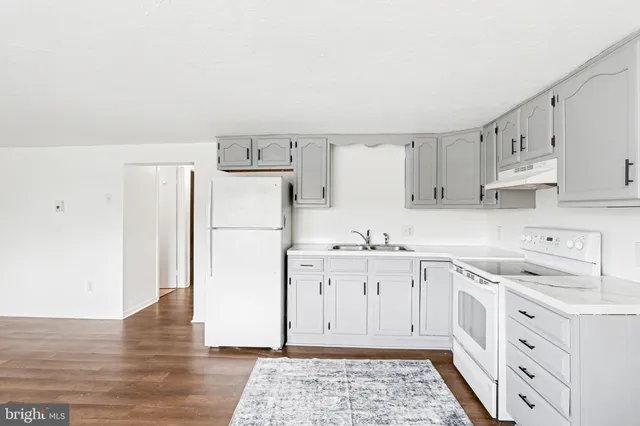 a kitchen with cabinets appliances a sink and a counter top space