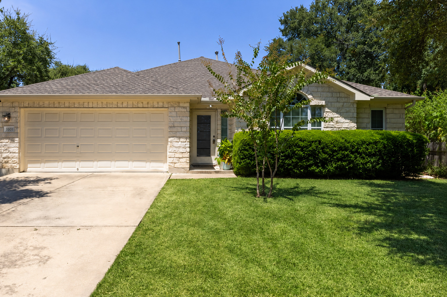 Limestone masonry and a neat lawn frame this classic single-story home with an attached garage. Virtually Enhanced.