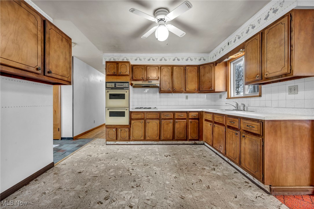 1140 Keefer Road Girard, OH 44420 - Photo 10 of 49 Kitchen with light countertops, brown cabinetry, tasteful backsplash, and a ceiling fan