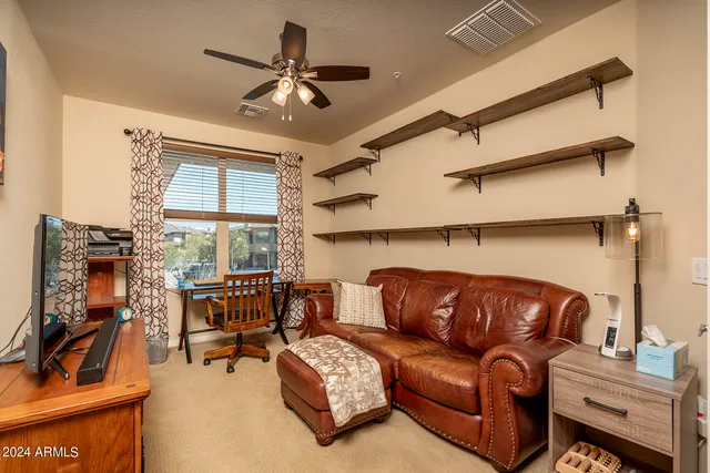 a living room with furniture a ceiling fan and a rug
