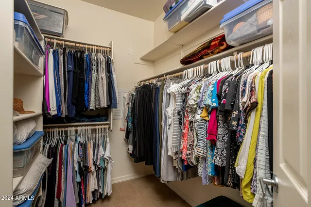 a view of walk in closet with clothes and shoes