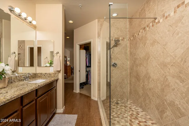 a bathroom with a granite countertop sink a shower and a mirror