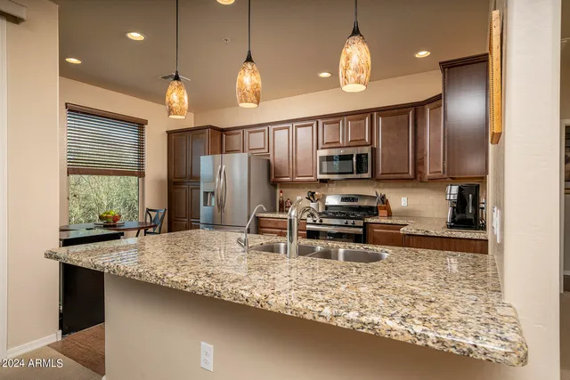 a kitchen with stainless steel appliances granite countertop a sink refrigerator and microwave