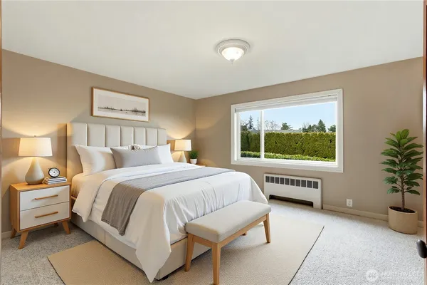 a bedroom with a large bed and a potted plant