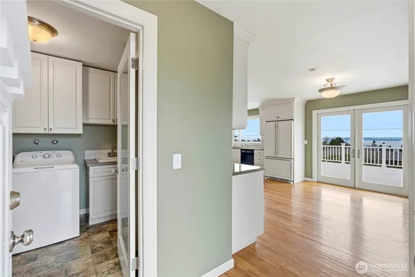 a view of a kitchen with refrigerator and wooden floor