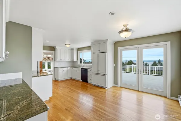 a dining room with furniture potted plants and wooden floor