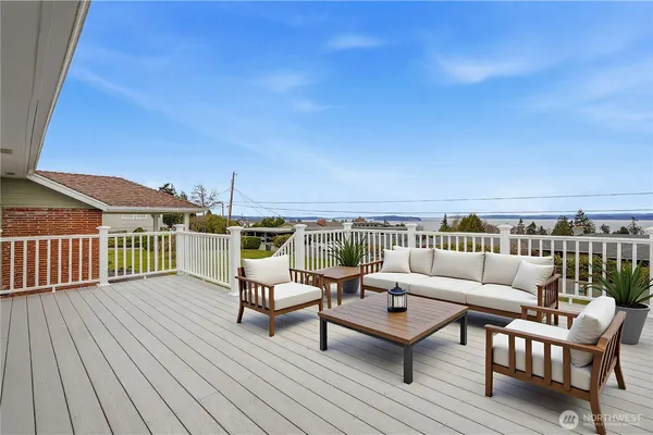 a large white kitchen with stainless steel appliances granite countertop a stove and white cabinets with wooden floor
