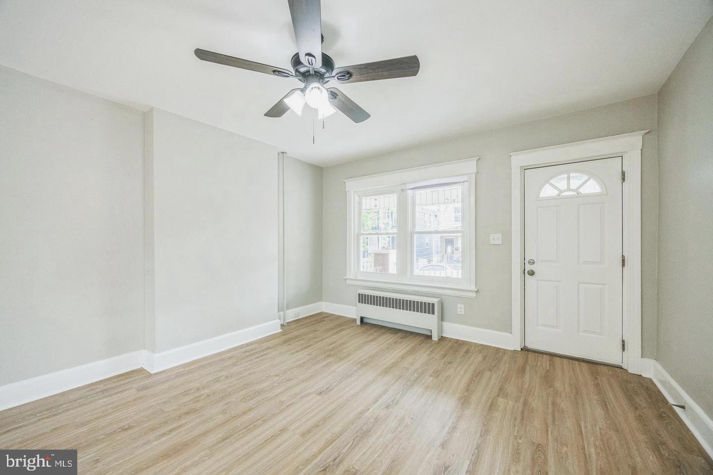 131 Columbus Avenue Trenton, NJ 08629 - Photo 3 of 12 an empty room with wooden floor fan and windows
