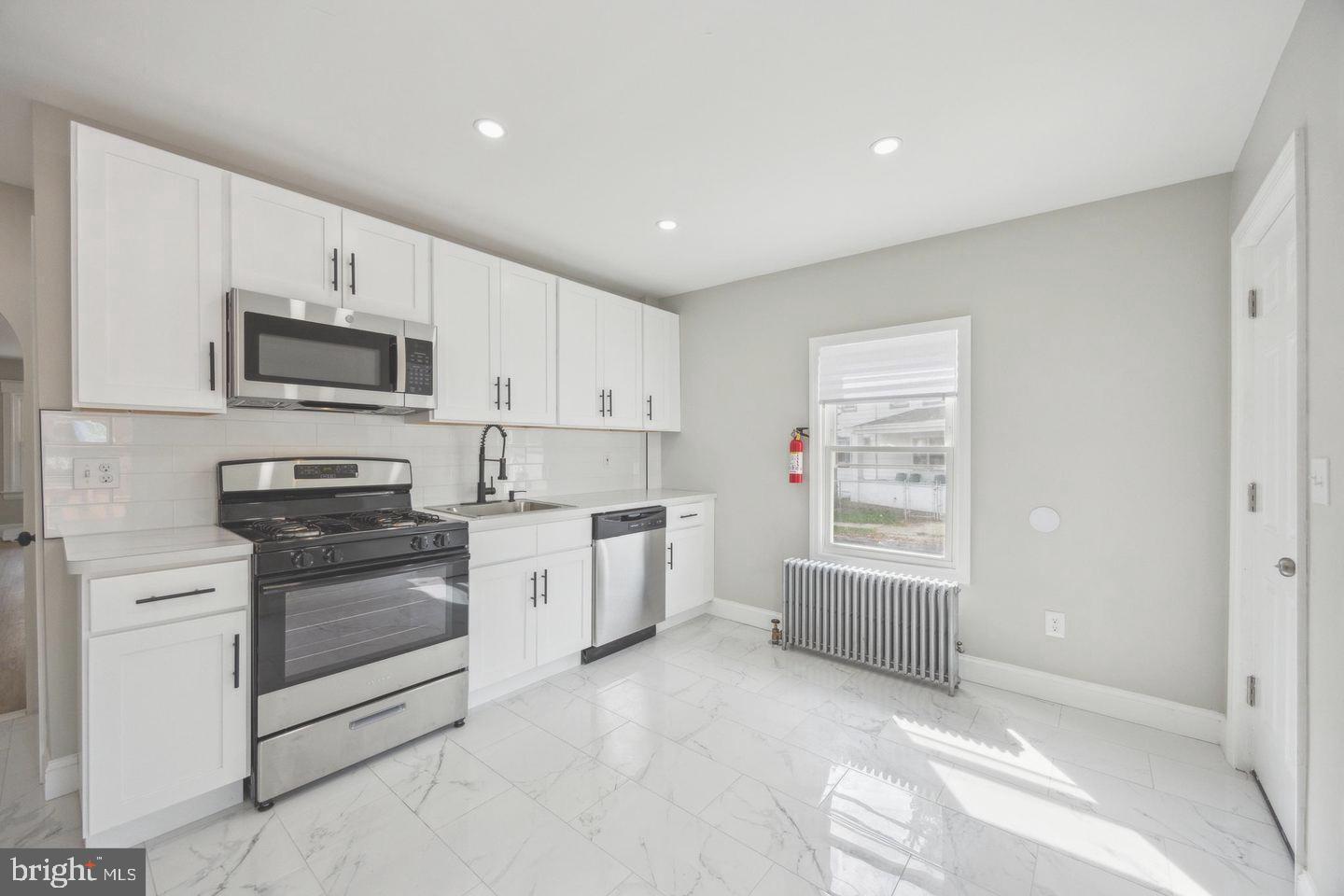 131 Columbus Avenue Trenton, NJ 08629 - Photo 5 of 12 a kitchen with granite countertop a sink stove and microwave