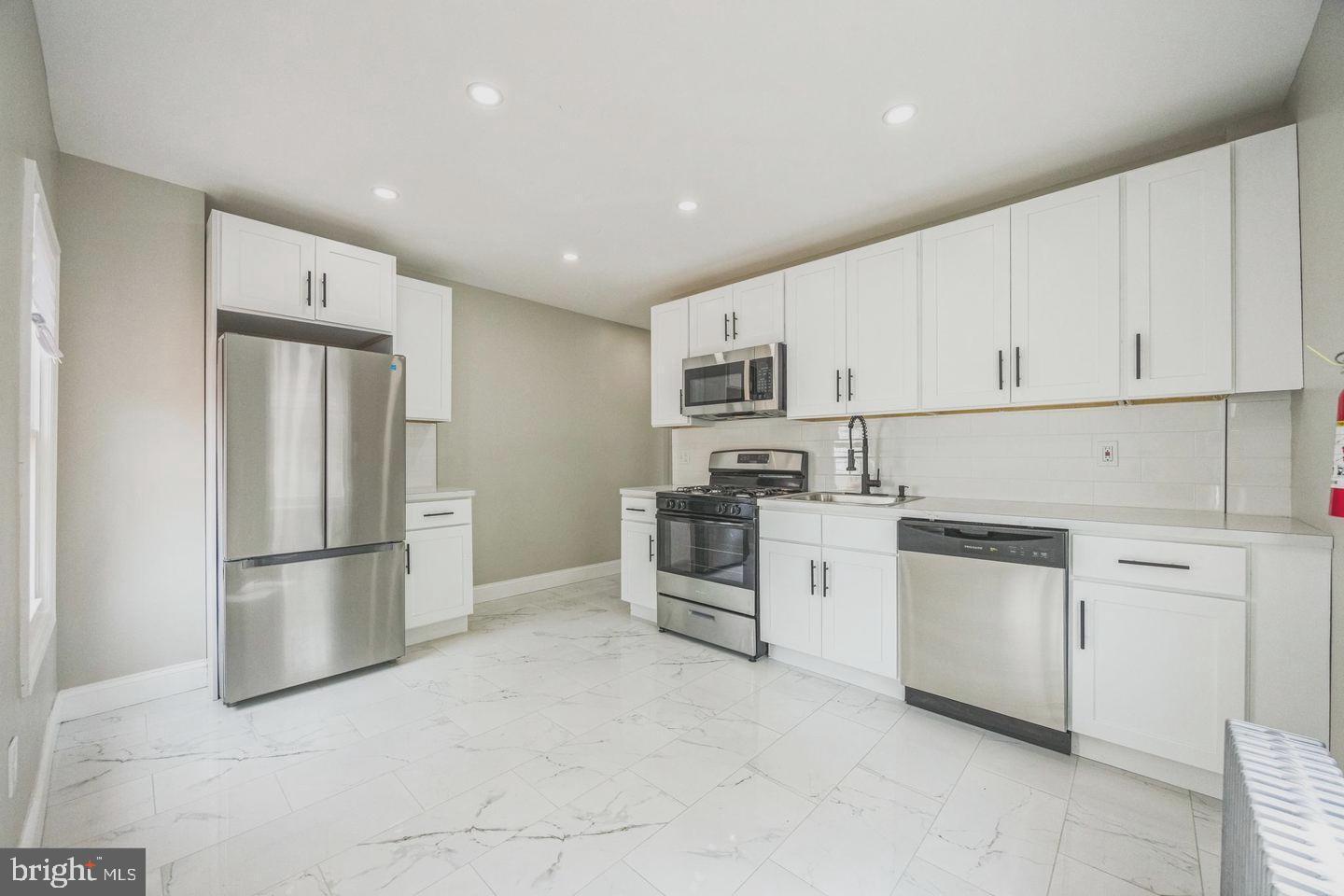 131 Columbus Avenue Trenton, NJ 08629 - Photo 6 of 12 a kitchen with white cabinets and stainless steel appliances