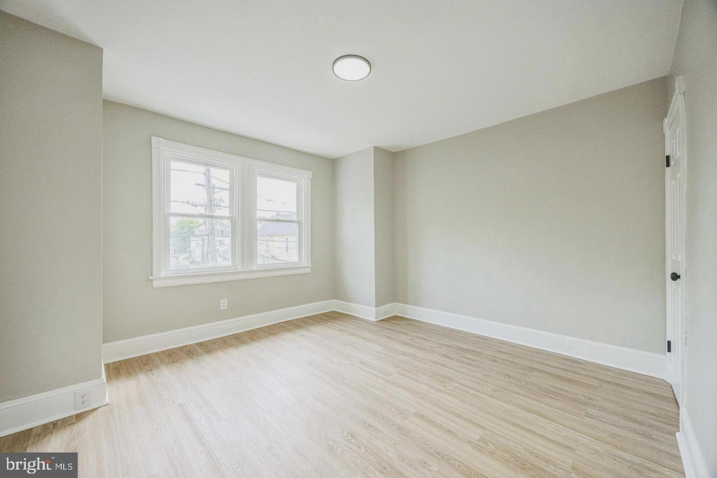 131 Columbus Avenue Trenton, NJ 08629 - Photo 7 of 12 an empty room with wooden floor and windows