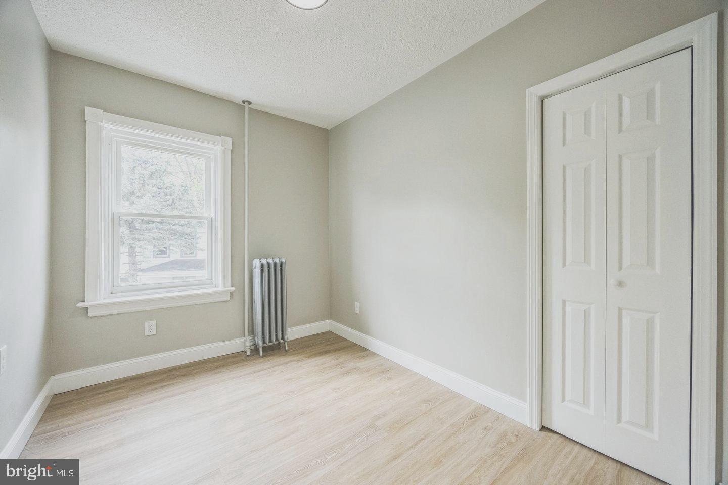 131 Columbus Avenue Trenton, NJ 08629 - Photo 8 of 12 an empty room with wooden floor and windows