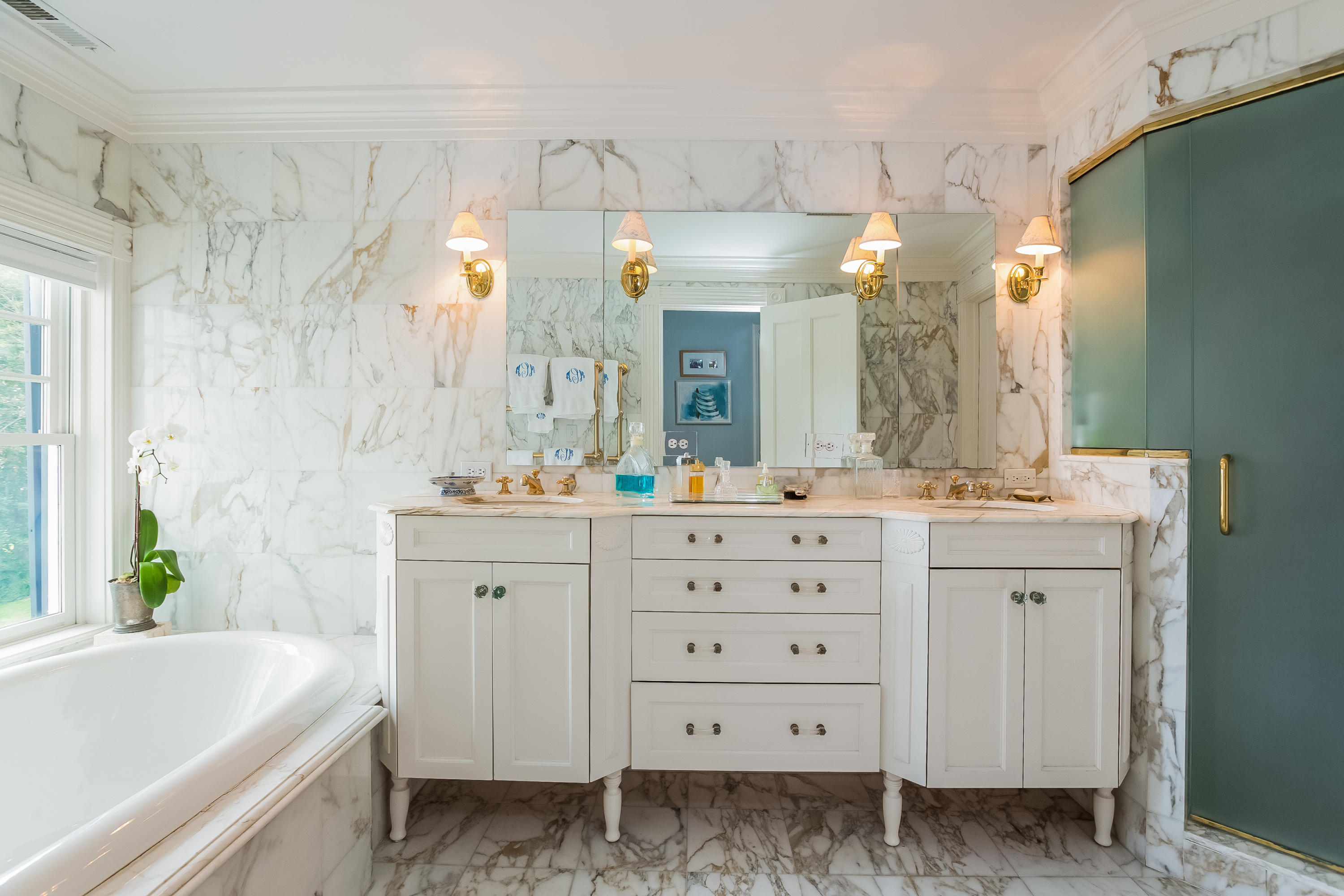 155 Long Neck Point Road Darien, CT 06820 - Photo 26 of 52 a bathroom with a double vanity sink a mirror a bathtub and a shower