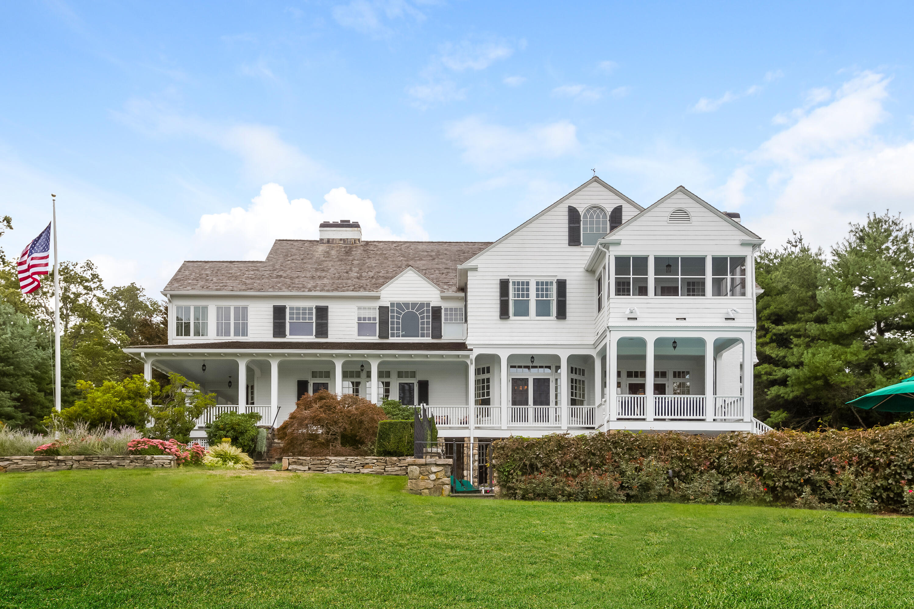 155 Long Neck Point Road Darien, CT 06820 - Photo 35 of 52 a front view of a house with a yard table and chairs