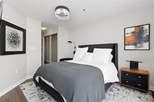 a bedroom with a bed and a lamp on dresser