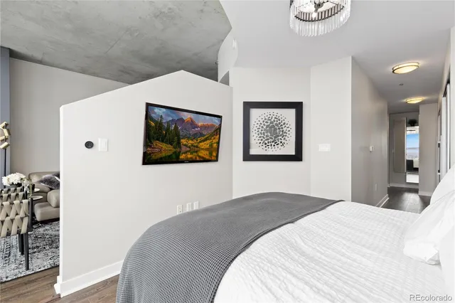a bedroom with a bed and a painting on the wall