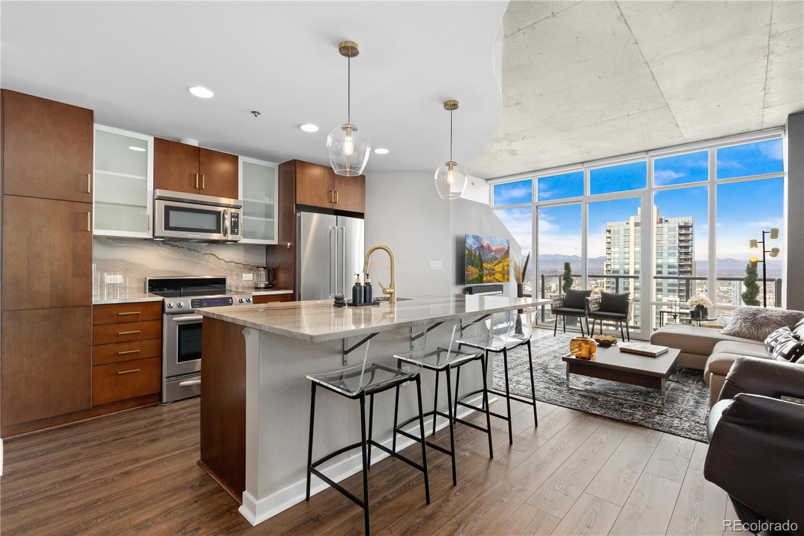 891 14th Street, Unit 4206 Denver, CO 80202 - Photo 7 of 49 a kitchen with stainless steel appliances granite countertop a stove a refrigerator a kitchen island a dining table and chairs with wooden floor
