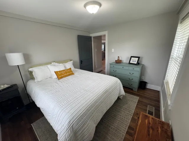 a bedroom with bed and wooden floor
