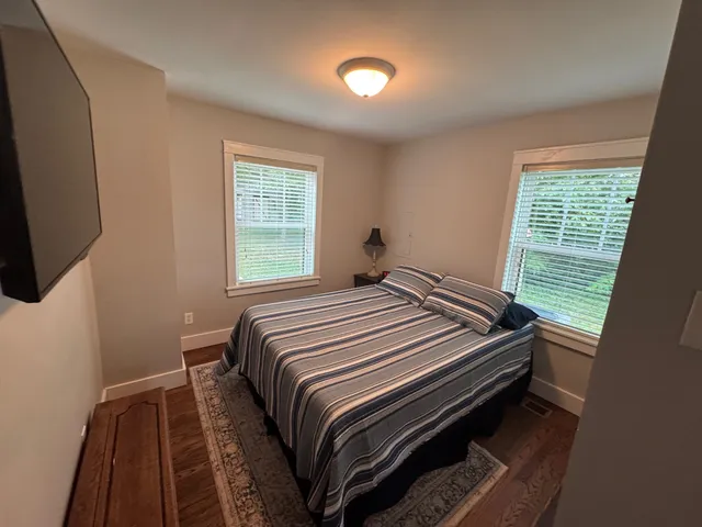a bed sitting in a bedroom next to a window