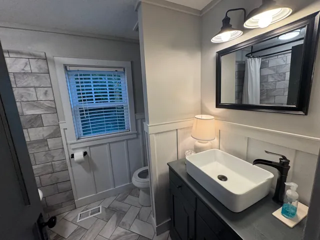 a bathroom with a toilet a sink and a mirror