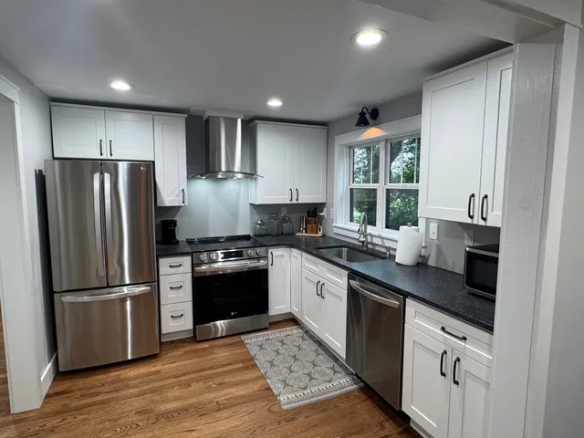 a kitchen with stainless steel appliances granite countertop a refrigerator sink and stove