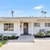 a front view of a house with a yard and potted plants