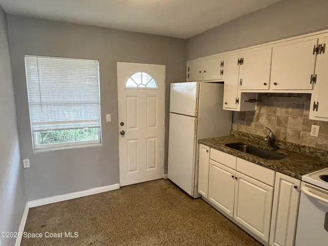 a kitchen with granite countertop cabinets and refrigerator