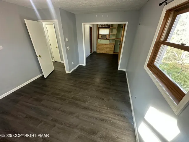 a view of a hallway with wooden floor and stairs