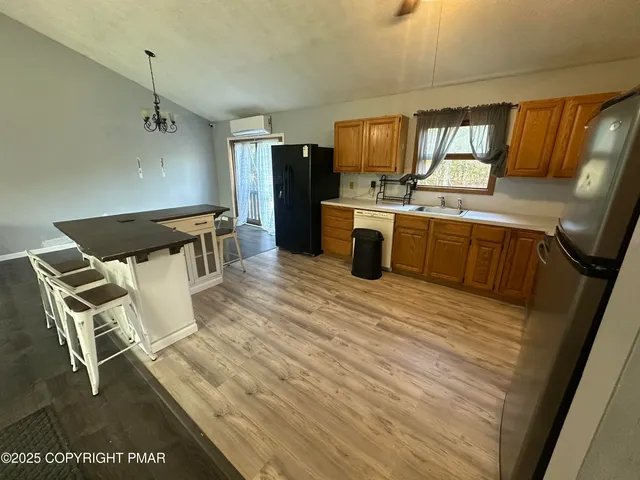 a kitchen with stainless steel appliances wooden floors and white cabinets