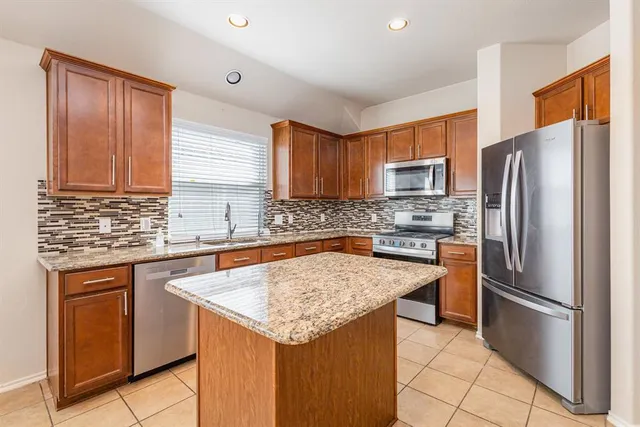 a kitchen with stainless steel appliances granite countertop a refrigerator sink and cabinets