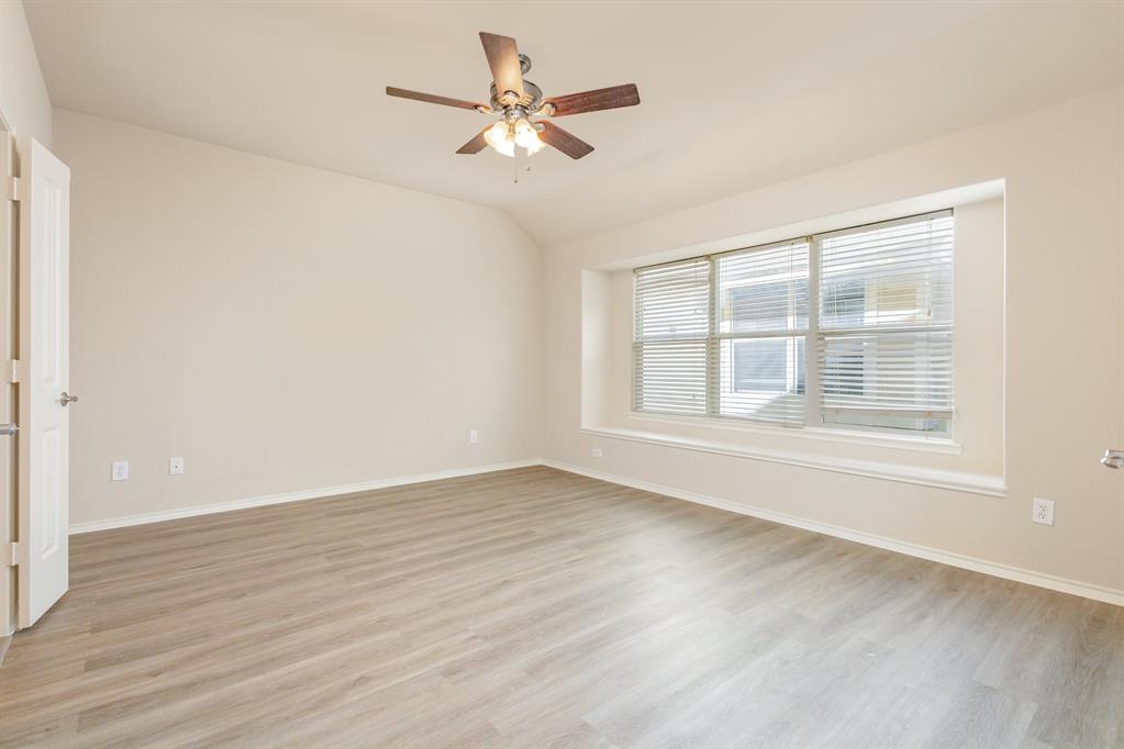 9732 Hedge Bell Drive McKinney, TX 75072 - Photo 15 of 24 an empty room with wooden floor fan and windows