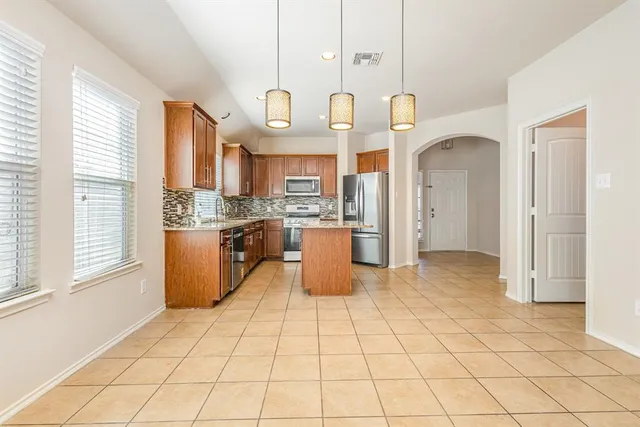 a kitchen with stainless steel appliances granite countertop a stove a sink and a refrigerator