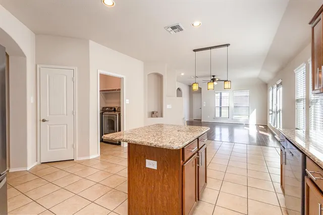 a kitchen with granite countertop a sink a counter top space and cabinets