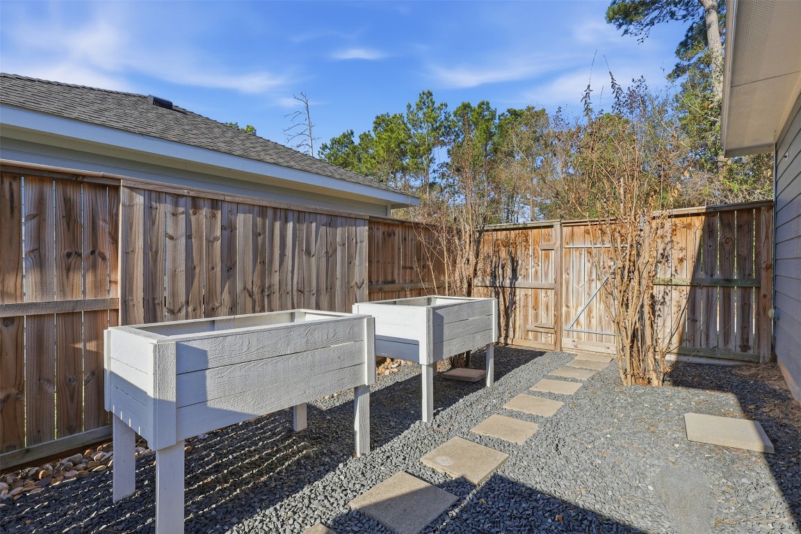 66 Whetstone Ridge Way Spring, TX 77382 - Photo 29 of 39 Limestone rock installed in fenced area next to the garage. This space features 2 elevated planters and a walkway leading to the back fence.