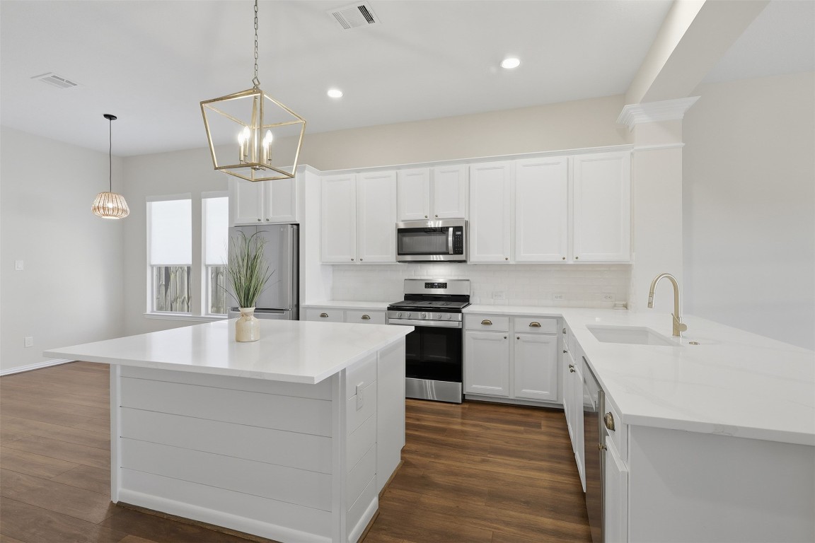66 Whetstone Ridge Way Spring, TX 77382 - Photo 4 of 39 Beautifully updated kitchen which includes stainless steel appliance package, quartz countertops, island with bar seating, recessed lighting and white cabinetry.