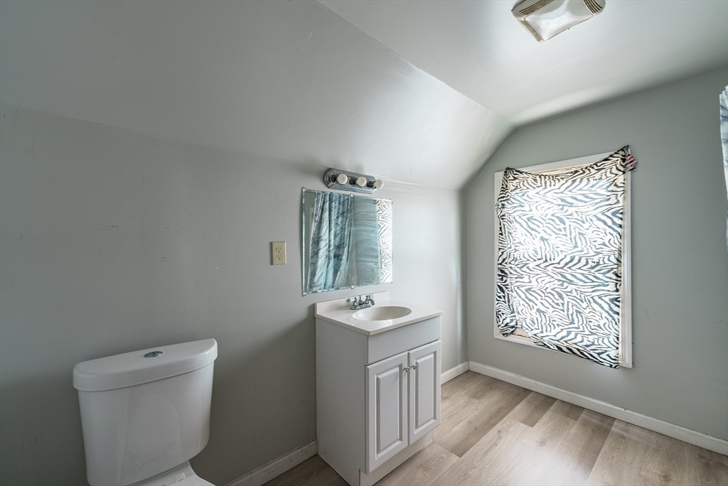 33 Littleton Street Springfield, MA 01104 - Photo 19 of 19 a bathroom with a granite countertop sink a toilet and a mirror