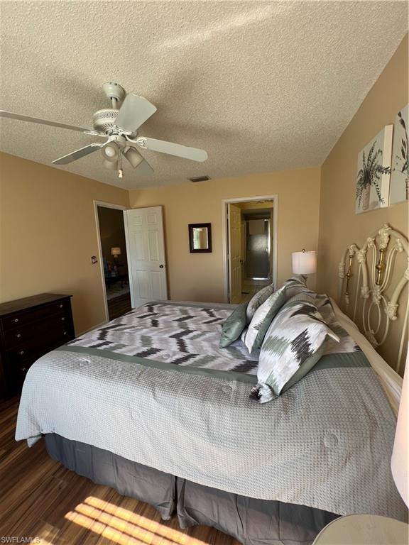 185 Grand Oaks Way, Unit R204 Naples, FL 34110 - Photo 13 of 18 a bedroom with a bed and a chandelier