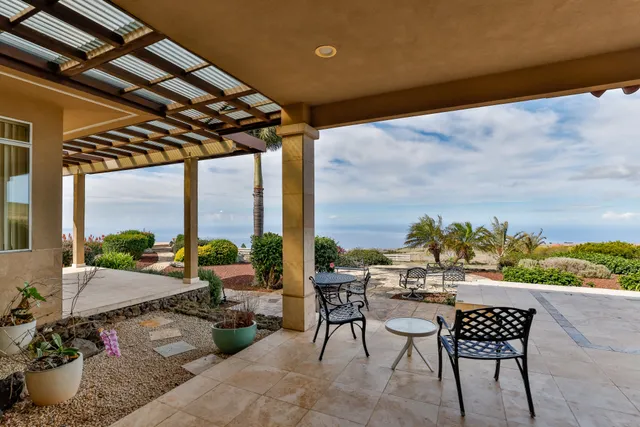 a roof deck with a table and chairs and potted plants