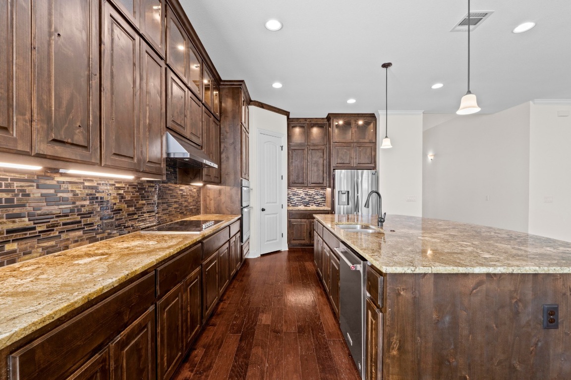 200 Tate Lane Round Rock, TX 78665 - Photo 11 of 40 a kitchen with kitchen island granite countertop a sink stove and cabinets