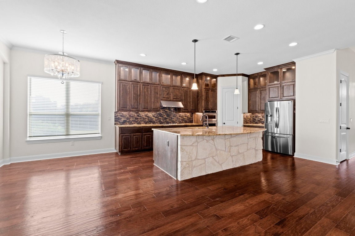 200 Tate Lane Round Rock, TX 78665 - Photo 9 of 40 a kitchen with stainless steel appliances kitchen island wooden cabinets and a wooden floor