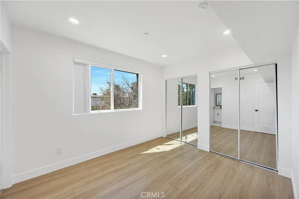 an empty room with wooden floor and window