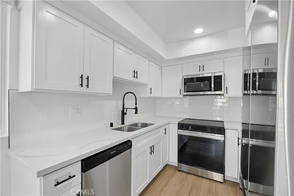 a kitchen with stainless steel appliances a refrigerator sink and microwave