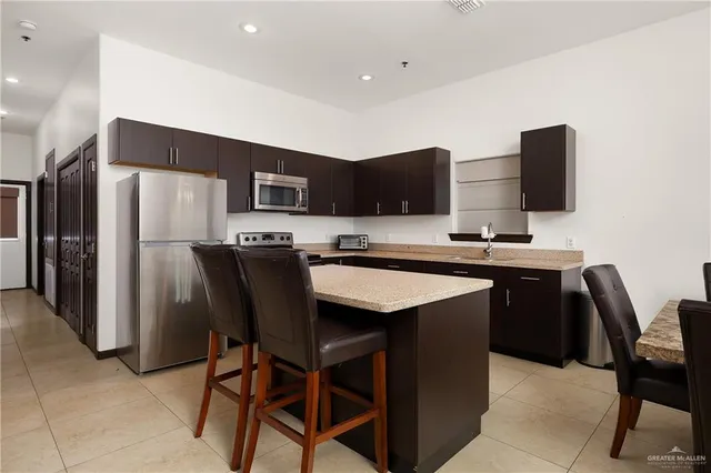 a kitchen with stainless steel appliances granite countertop a refrigerator a stove a sink and a stove