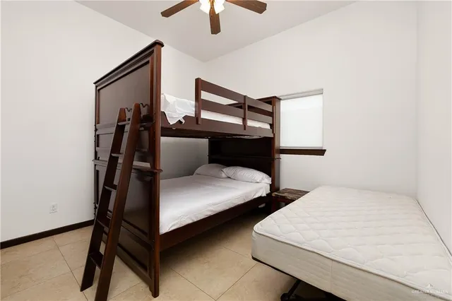 a bedroom with two beds and ceiling fan