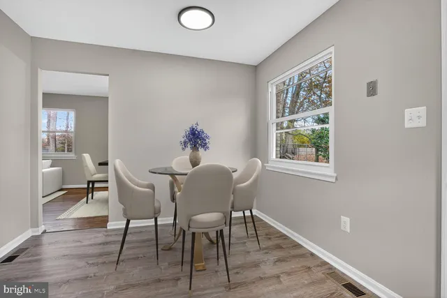 a dining room with wooden floor a glass table and chairs