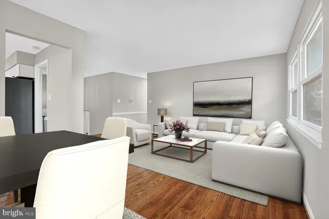 a living room with furniture a table and kitchen view