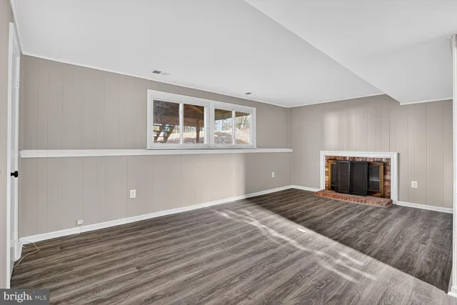 a view of a livingroom with wooden floor and staircase