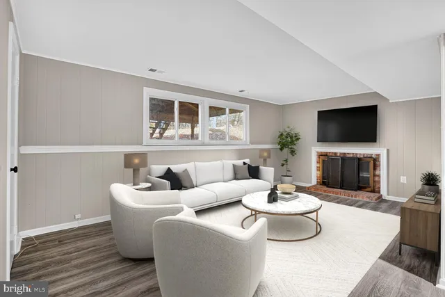 a living room with furniture a flat screen tv and a fireplace