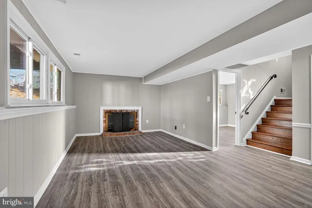 a view of empty room with wooden floor and entryway