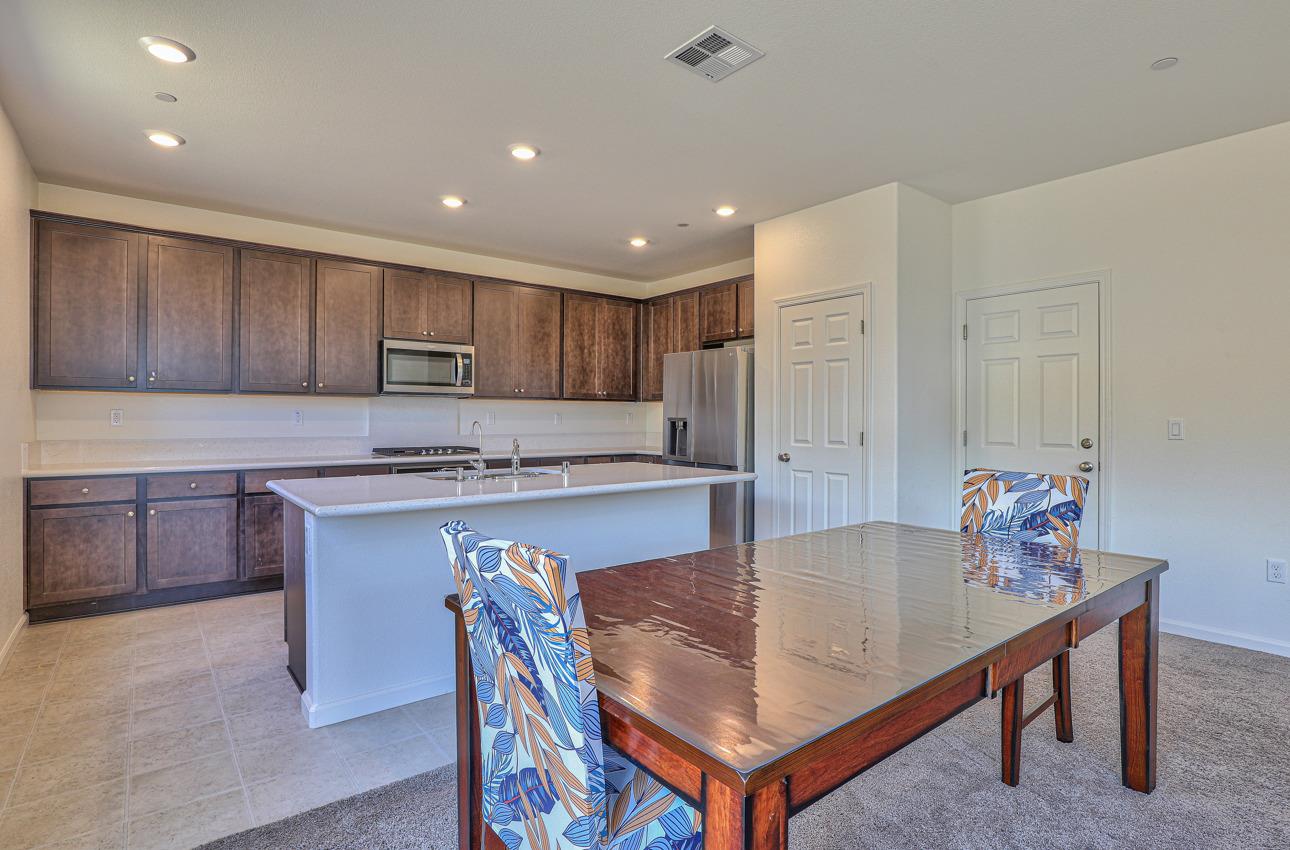 1400 Winzer Place Gilroy, CA 95020 - Photo 15 of 33 a kitchen with granite countertop a table chairs sink microwave and cabinets